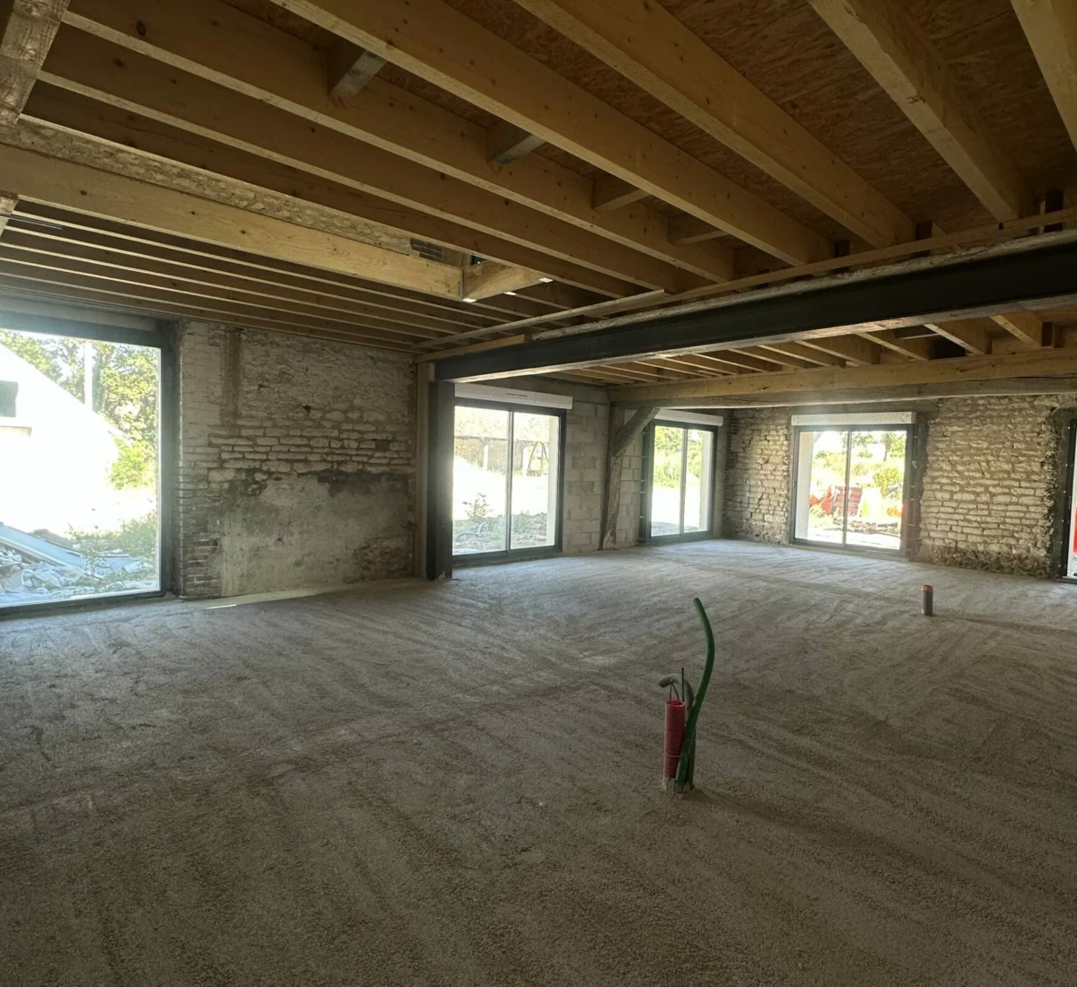 Chantier de gros œuvre : plancher bois et poutre acier dans une maison en pierre
